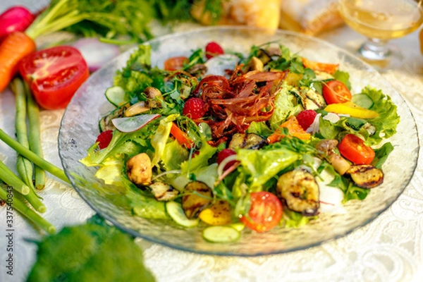 Fototapeta Fresh salad with dried meat, herbs and vegetables served on the table with the ingredients, healthy food