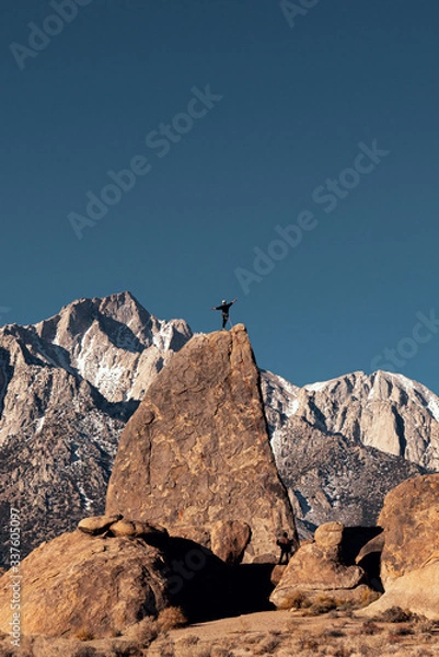 Obraz Mountain climber standing on rock peak in Eastern Sierra Nevada mountains