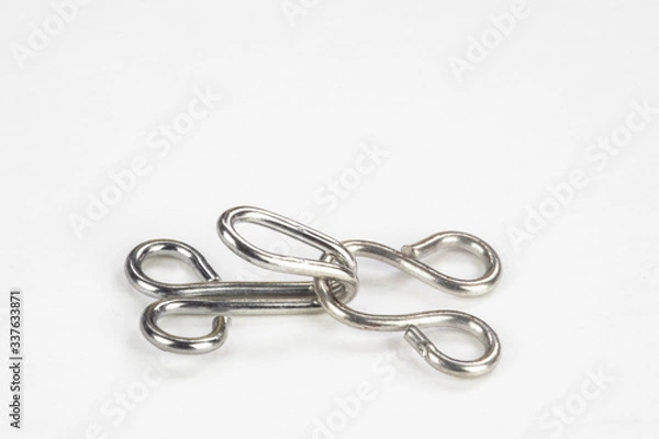 Fototapeta Close up macro of a dress making hook and eye isolated on a white background