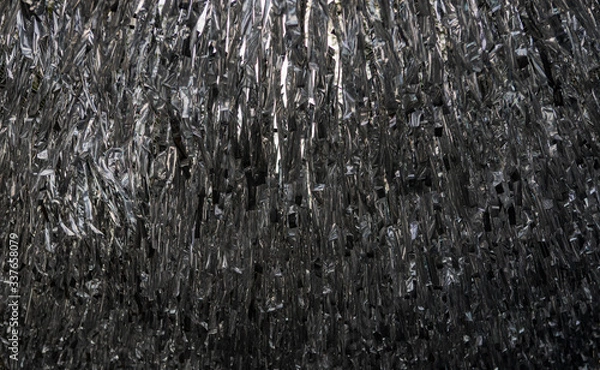 Obraz silver plastic strings hanging from ropes above a walking street