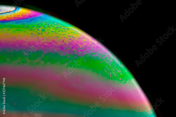 Fototapeta Psychedelic abstract planet from soap bubble, Light refraction on a soap bubble, Macro Close Up in soap bubble. Rainbow colors on a black background. Model of Space or planets universe cosmic galaxy.
