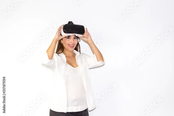 Obraz Bella ragazza utilizza caschetto visore VR per la Realtà Virtuale sorridente e felice Isolata su fondo bianco