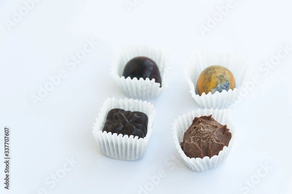 Fototapeta Four handmade chocolate sweets isolated on a white background. Close up