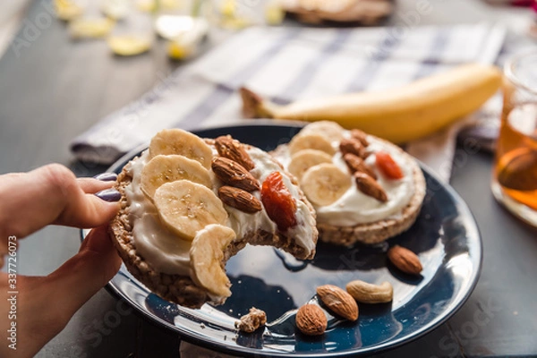 Obraz eating breakfast at home. cup of tea with lemon and banana and almond toast. breakfast at home. breakfast idea. simple breakfast decoration. eating a toast