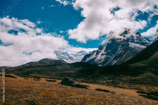 Fototapeta Beautiful mountain peaks and soft white clouds