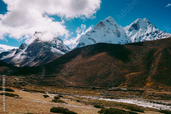 Fototapeta Beautiful mountain peaks and soft white clouds