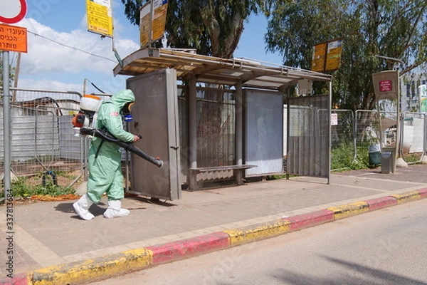 Obraz A person disinfects a bus stop from the Corona virus.
