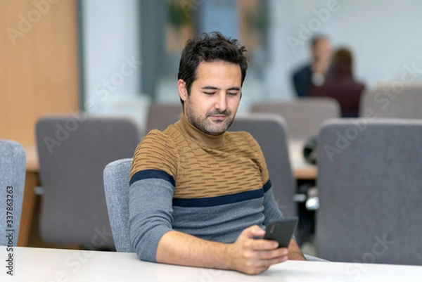Obraz A handsome man texting with his lover on a smartphone