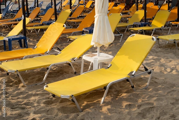 Fototapeta Rows of yellow empty beach beds.