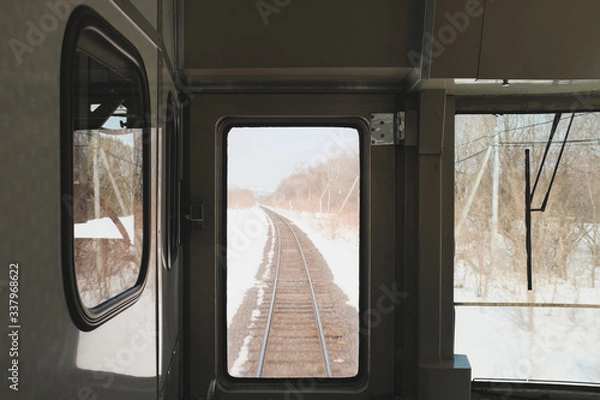 Fototapeta Winter in the hokkaido region, the train tracks are covered in snow, a memorable sight for travelers.