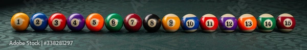Obraz Billiard balls arranged in a row close-up on a green backgound. Wide frame.