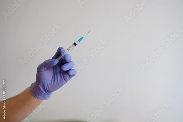 Obraz Hand holding syringe and vaccine for the covid-19 virus, against the corona epidemic / vaccine isolated on white background