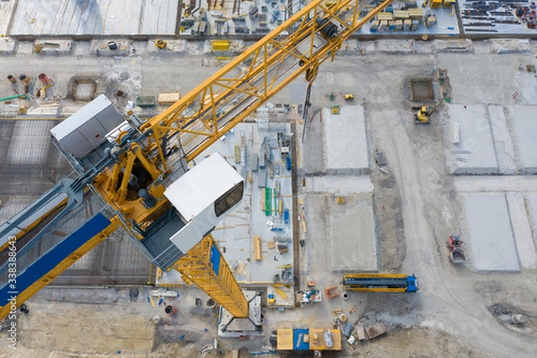 Obraz big yellow crane on construction building site with aerial view from top