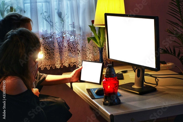 Obraz Young women in mourning are looking on computer screen and crying. Computer set with snitch and picture frame template. Sad girls in black are watching funeral live stream. 