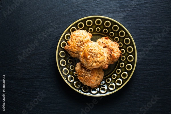 Fototapeta Oriental food concept homemade Chinese Sesame Cookie in green ceramic plate on black slate stone board with copy space