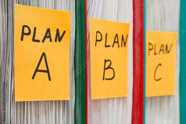 Obraz Three folders with stickers, on which plan a, b or c is written. Business planning. A spare option. Difficulties of enterprise management. Decision making, development options. Background in blur.