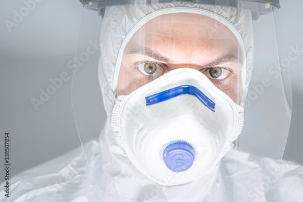 Fototapeta Portrait of man doctor in protective clothes during coronavirus pandemic. Epidemic, pandemic of coronavirus COVID 19