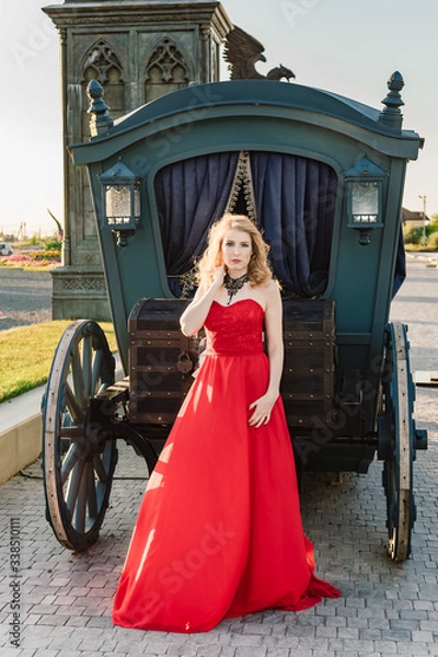 Obraz A woman in a red dress stands on a background of a medieval castle