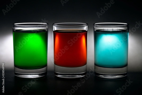 Obraz three glowing shot glasses with colorful drinks