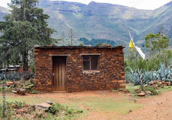 Obraz A rural hut in the mountains of Lesotho, Africa with a yellow flag signalling the sale of homemade beer