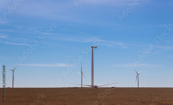 Fototapeta A panoramic view of the windmill installed in a field installation wind turbine with blue sky background