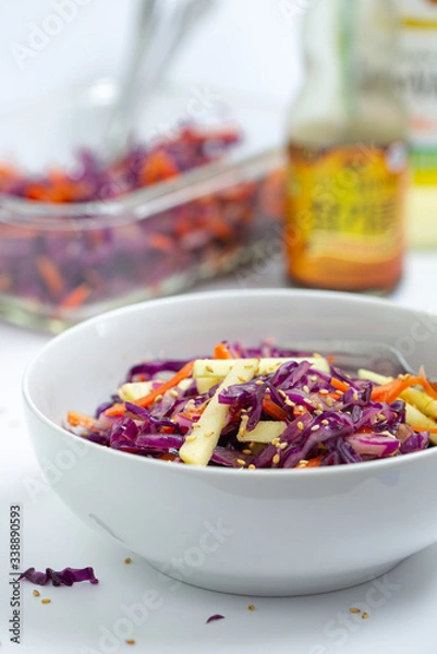 Fototapeta Vegetarian salad with red cabbage, carrot and apple.