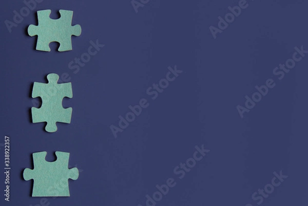 Obraz Three puzzle pieces on blue background.copyspace for text.