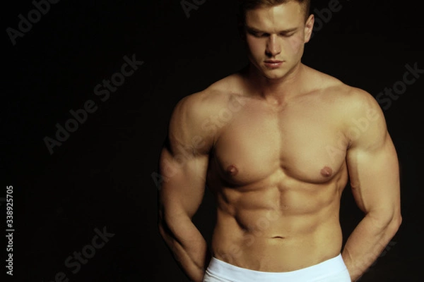 Obraz Strong stripped muscle male model in white underwear on black isolated font background
