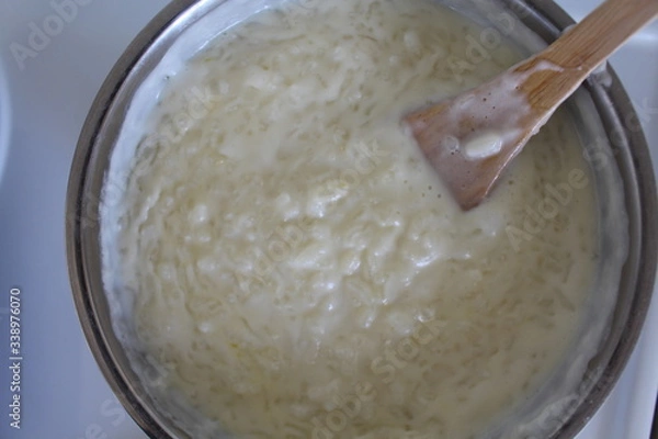 Fototapeta Cooking of rice porridge on oven, the first stage of preparation of national Finnish dish from rye flour and rice - Karelian pies