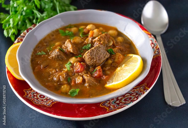 Obraz Moroccan soup harira with meat chickpeas lentil tomato and spices. Served Iftar holy month of Ramadan. Dark background.