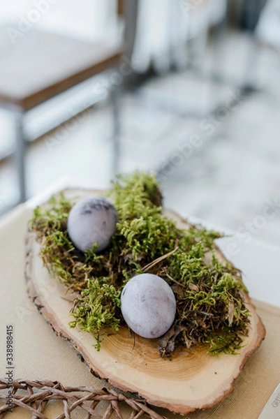 Fototapeta Home table decor. Festive table composition for traditional holiday dinner, decorated with moss, eggs, spring flowers. Happy easter concept