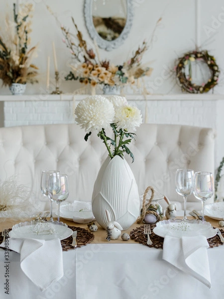 Fototapeta Home table setting decor. Elegant white and brown colors. Festive table for traditional holiday dinner, decorated with spring flowers, napkins and eggs. Happy easter