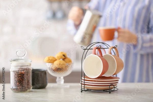 Fototapeta Holder with cups and saucers on table