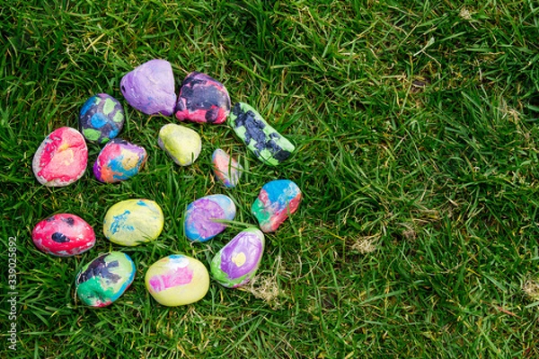 Fototapeta Rocks painted by a child with bright colors; painted rocks arranged in a circle