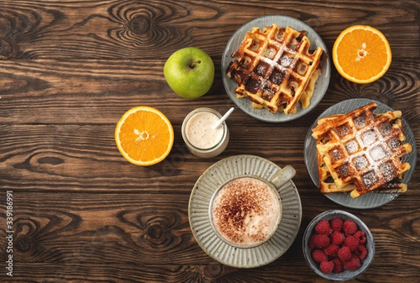 Obraz Belgian waffles, coffee, yogurt, fruits and berries on a wooden background, breakfast concept.