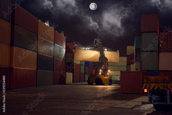 Obraz reach stacker puts container in stack. industrial port with containers