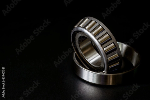 Fototapeta Closeup of Tapered roller bearing with copy space for your text. Spare part of mechanical on the black background..