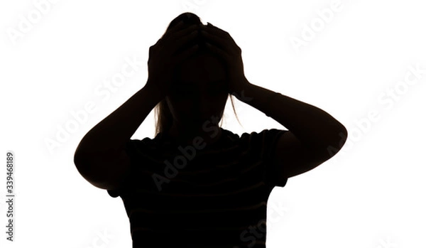 Fototapeta silhouette of a young woman in stress clasped her head on a white isolated background, concept female emotions, fear and depression