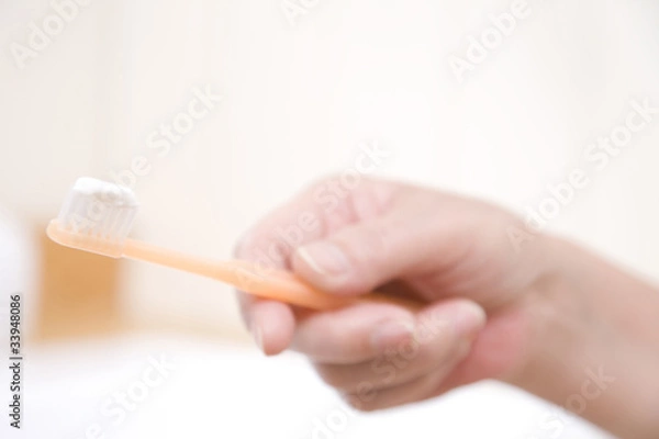 Fototapeta 歯ブラシを持つシニア女性の手元