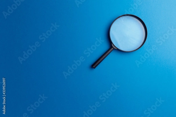Obraz Concept information search. Magnifying glass on classic blue background. Top view. Flat lay. Copy space. Minimal creative concept. Trendy color. Searching information data on internet
