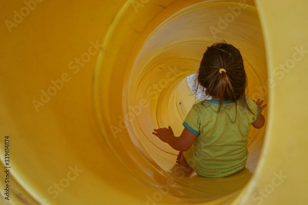Obraz Little girl playing at playground during recess on swing and slide