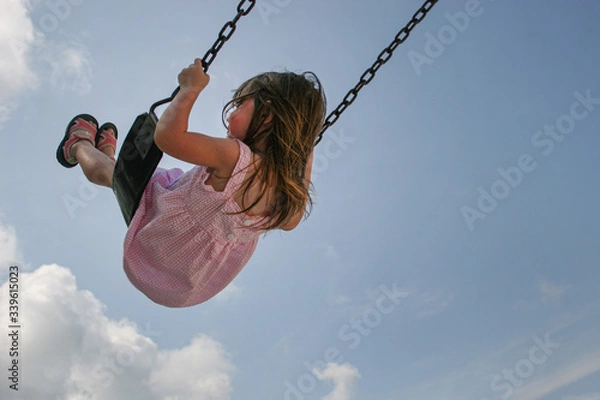 Obraz Little girl playing at playground during recess on swing and slide