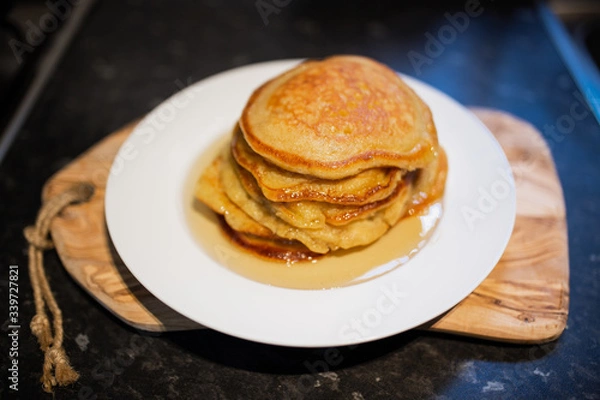 Fototapeta Fresh homemade classic pancakes with maple syrup in a white plate on a wooden board.