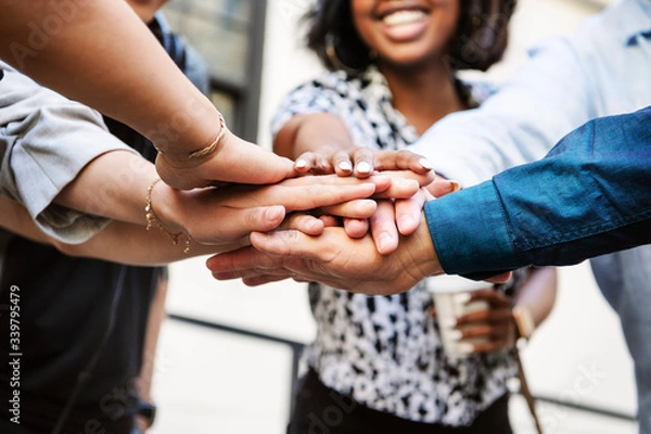 Fototapeta Diverse startup business team stacking hands
