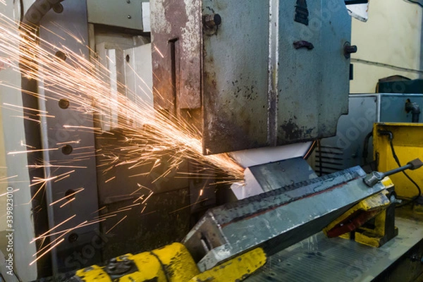 Fototapeta Grinding on a magnetic turntable on a surface grinding machine, grinding the angular surface of the sun table with abrasive stone with water cooling.