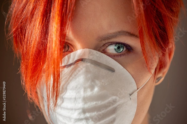 Obraz close-up face of young woman in putting on face mask