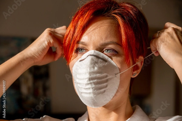Obraz face of young woman in putting on face mask