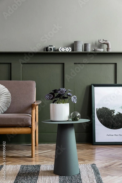 Fototapeta Stylish interior design of living room at cozy apartment with stylish sofa, plants, design furnitures, decoration and elegant accessories. Mock up poster frames on the shelf.  Home staging.