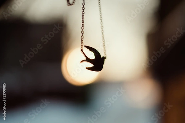 Fototapeta pendant in the form of a bird tit on a chain