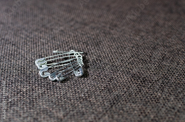 Fototapeta several pins on gray fabric